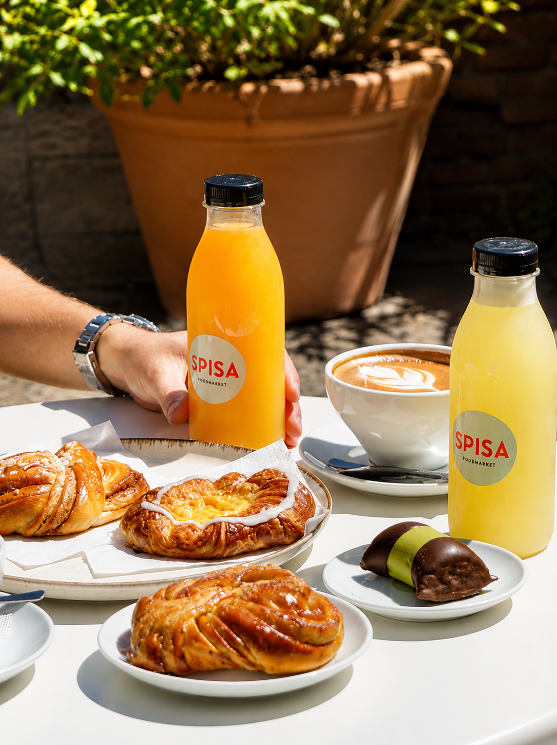 Spisa café table with fresh juice, coffee and pastries